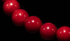 a row of red beads on a black background