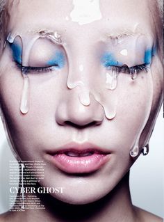 a woman's face with blue eyes and white make - up on the cover of a magazine