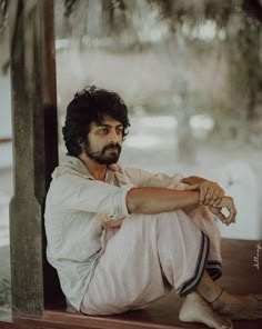 a man sitting on top of a wooden bench