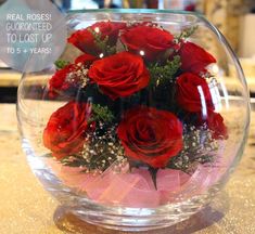 a vase filled with red roses on top of a table