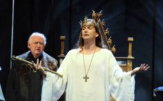 a man dressed as jesus standing next to another man in a crown on his head