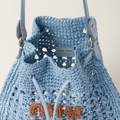 a blue crocheted bag with two handles