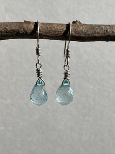 "Blue Topaz Earrings, Sky Blue Teardrop Earrings in Sterling silver, December Birthstone, Sterling silver Jewelry, Gift for Mom These dainty and classic earrings feature generous size perfect faceted Sky blue topaz briolettes wire wrapped sterling silver. The elegant mysterious blue earrings are suspended from sterling silver French hooks Earwires.  Ideal for an anniversary gift or a December Birthday gift, or that perfect soft color earring to never take off, these crystal clear blue earrings are a forever piece of jewelry that can remain in your family for generations to come.  About These Earrings: * Stone: Sky Blue Topaz * Birthstone Month: December * Stone Size: 10 mm x 8 mm * Earrings Length: 1&1/4\" * Finish: Sterling silver  * Secure Lever Back Ear Wires  * Gift Wrapping Included * Silver Topaz Teardrop Earrings, Blue Topaz Teardrop Earrings, Silver Teardrop Topaz Earrings, Blue Topaz Teardrop Birthstone Earrings, Teardrop Blue Topaz Birthstone Earrings, Silver Topaz Birthstone Earrings, Silver Briolette Blue Topaz Jewelry, Silver Blue Topaz Briolette Jewelry, Silver Aquamarine Dangle Earrings