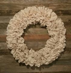 a wreath made out of fabric on top of a wooden wall with the word love written in