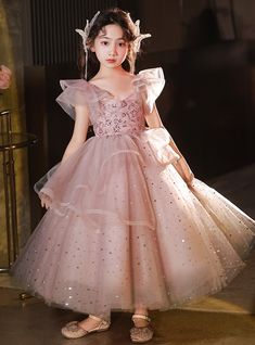 Accentuating a sense of delicate beauty, this flower girl dress is a perfect choice for creating a memorable look. The blush pink bodice is intricately decorated with sequins, adding a touch of glamour to the dress. The ruffled sleeves provide a whimsical feel, while the full skirt, crafted from layers of soft tulle, adds volume and grace. The glittery dots scattered throughout the skirt catch the light beautifully, making the dress sparkle with every twirl. Ideal for weddings, formal events, or special occasions, this dress combines style and comfort seamlessly. The soft, breathable lining ensures that your little one stays comfortable throughout the day, while the durable construction promises longevity. The dress also features an easy-to-use zipper and adjustable fit for convenience. Wi Sequin Flower Girl Dress, Dress Sparkle, Princess Flower Girl Dresses, Princess Flower, Fantasy Dresses, Delicate Beauty, Soft Tulle, Pink Tulle, Ruffled Sleeves