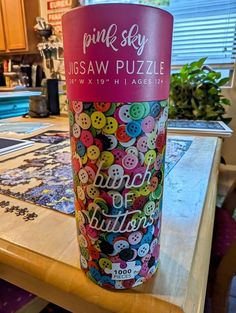 the pink sky jigsaw puzzle cup is sitting on top of a wooden table