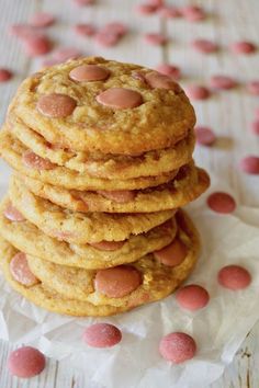 a stack of cookies sitting on top of each other next to pink candies in the background