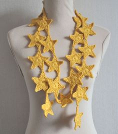 a white mannequin with yellow crochet stars on it's neck