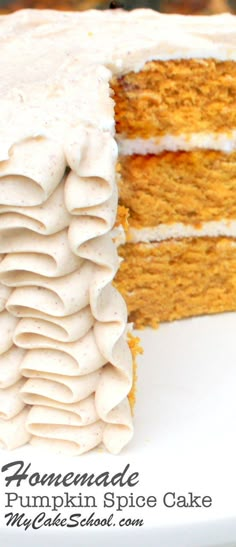 a pumpkin spice cake with white frosting is cut from the side and sits on a plate