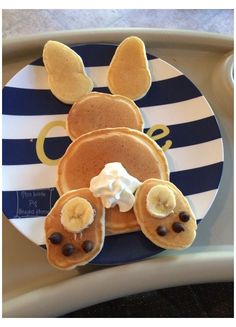 a plate topped with pancakes covered in toppings on top of a blue and white striped tray