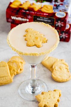 a dessert in a glass with cookies on the side and a box of crackers behind it