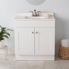 a bathroom with a sink, mirror and potted plant on the floor in front of it