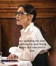 a woman sitting at a table in front of a laptop computer with a quote on it