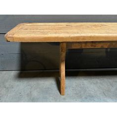 a wooden bench sitting on top of a cement floor