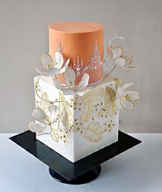 a three tiered cake with orange and white frosting