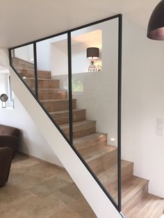 a stair case with glass panels and wooden steps