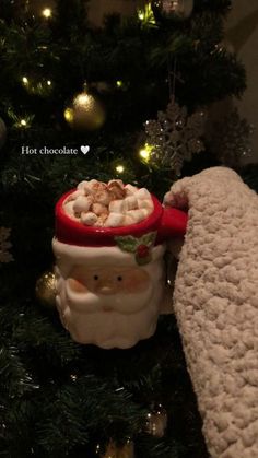 a christmas ornament with a santa clause holding a bowl of hot chocolates