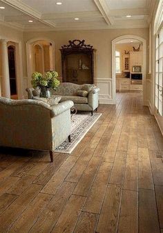 a living room filled with furniture and lots of windows on top of wooden flooring