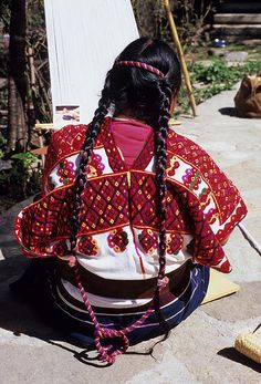 a woman with braids sitting on the ground