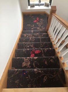 the stairs are decorated with flowers and butterflies on black carpeted steps leading up to a window