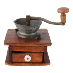 an old metal bowl on top of a wooden stand