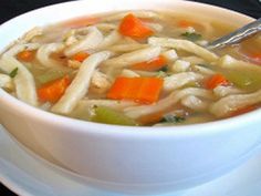 a bowl of chicken noodle soup with carrots, celery and noodles