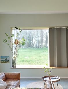 a living room filled with furniture and a large window covered in blinders over the windows