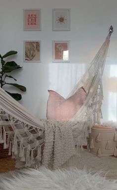 a white hammock in a room with pictures on the wall