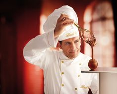 a man with a chef's hat holding a whisk over his head