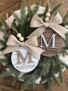 a wreath with two ornaments hanging from it's sides and the words merry written on them