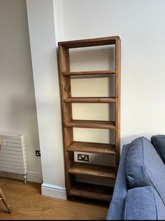 a wooden shelf sitting next to a blue couch