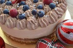 there is a cake on the table with berries and chocolate frosting in front of it