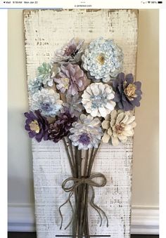 a bunch of flowers are in a vase on the floor next to an old window