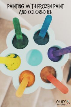 an ice cream tray with four different colored popsicles in it and the words, painting with frozen paint and colored ice