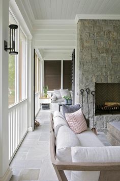 a white couch sitting on top of a stone covered porch