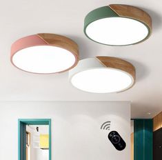 three circular lights are mounted on the ceiling above a bed in a room with white walls and green trimmings