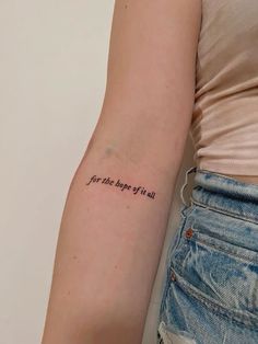 a woman with a tattoo on her arm saying for the age of all