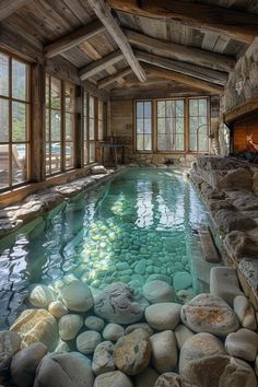 an indoor swimming pool surrounded by rocks and windows