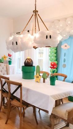 a dining room table and chairs with balloons in the shape of mario's mushroom