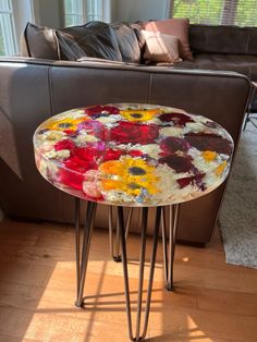 a table with flowers painted on it in front of a couch