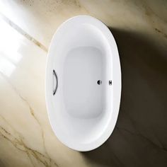 an oval shaped bathtub sitting on top of a marble counter