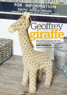 a stuffed giraffe sitting on top of a wooden table