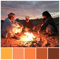 three people sitting around a campfire with oranges and browns in the foreground