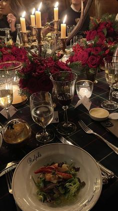 a table set for dinner with candles and flowers