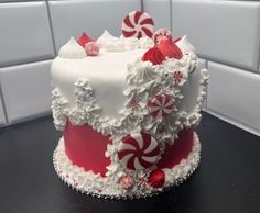 a large white and red cake with candy canes on it's side sitting on a counter