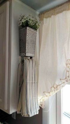 a potted plant sitting on top of a window sill next to a curtain