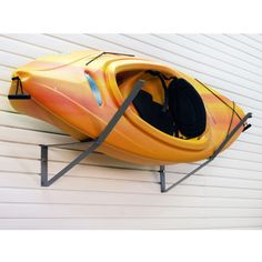 an orange kayak sitting on top of a white wall