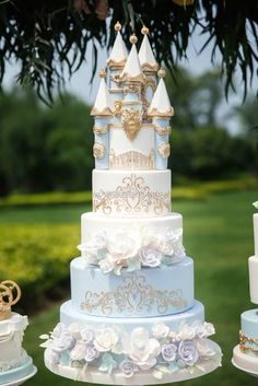 a multi layer cake sitting on top of a table covered in white and blue frosting