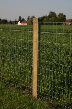 a wire fence in the middle of a field