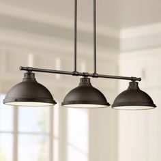 three lights hanging from the ceiling in a kitchen